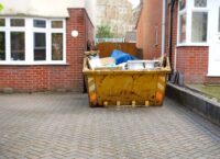 Full,Yellow,Rubbish,Skip,On,Driveway,,One,Side,Of,Frame. Full,Yellow,Rubbish,Skip,On,Driveway,,One,Side,Of,Frame.